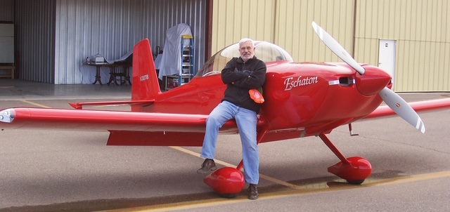 J.P. Barelli standing with his red RV-8 airplane named Eschaton